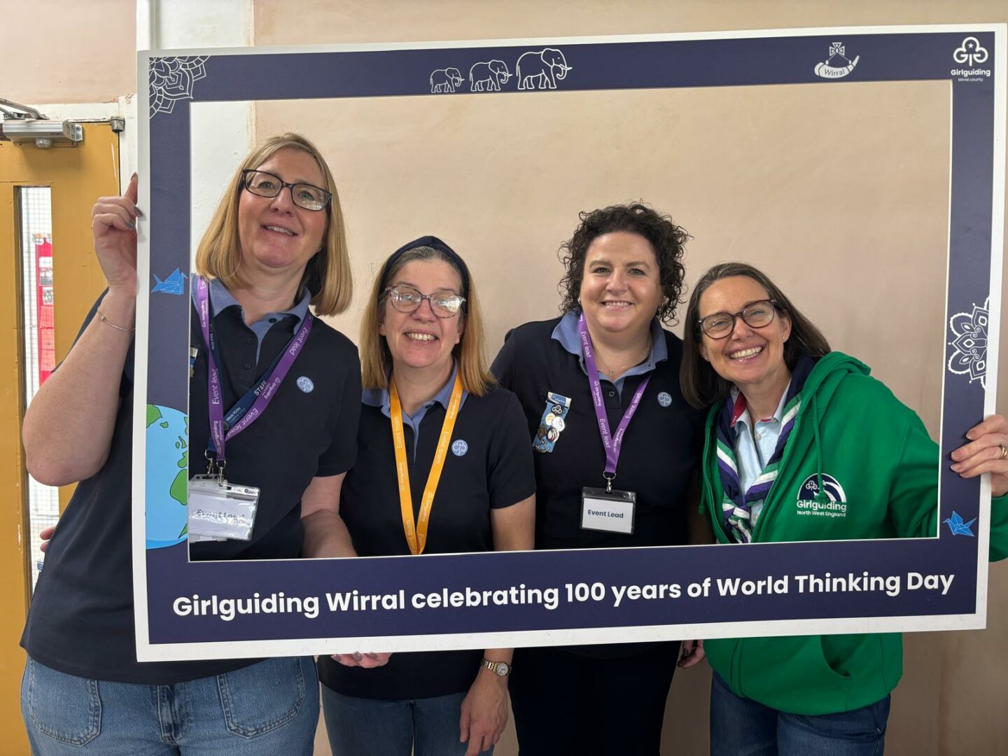 Image shows Rona and 3 volunteers at the WTD event in Wirral. All 4 are looking through a frame and smiling.
