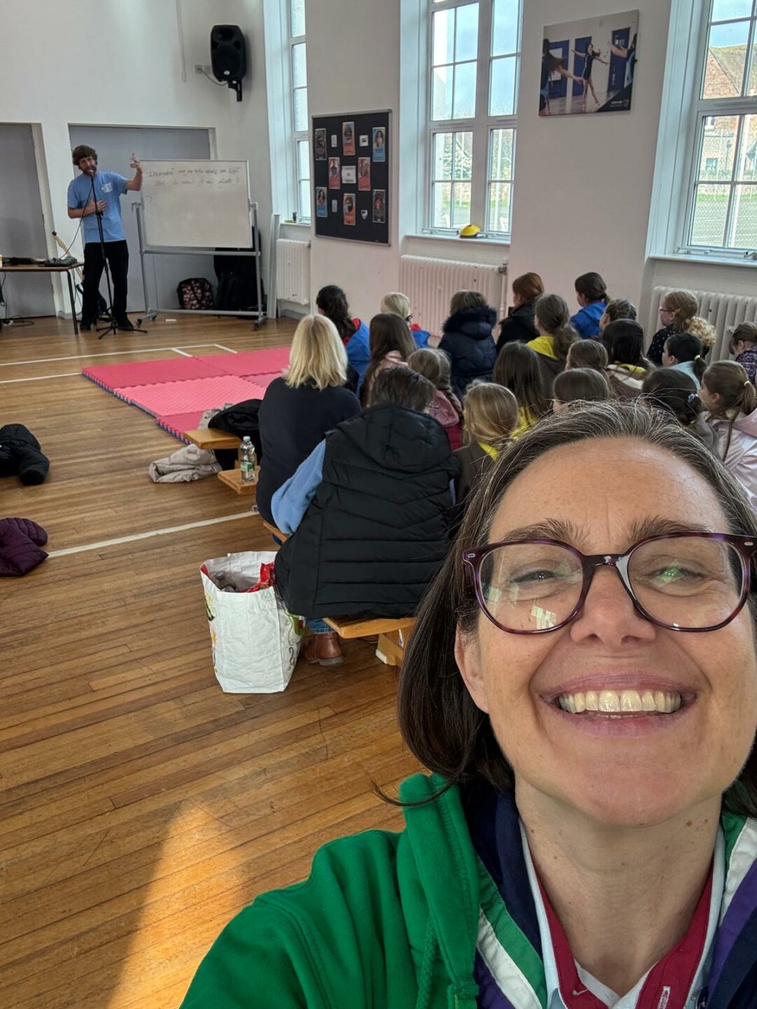 Image is a selfie taken by Rona at an event with several members in the background