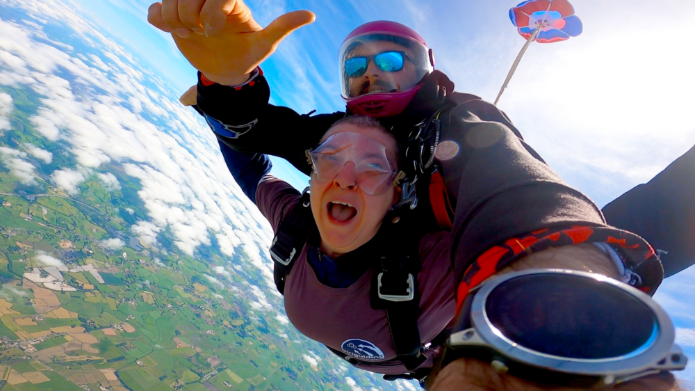 An image of a GGNWE member participating in a tandem skydive.